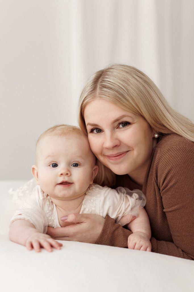 Äiti ja vauva katsovat kameraan - Perhekuvaus Jyväskylässä.